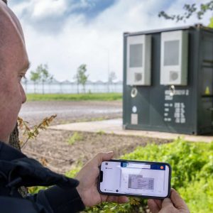 Vleeskuikenbedrijf Nuijten in Made. Kees Nuijten kijkt op de energie-app van zijn batterijcontainer (NB Het systeem is op dat moment buiten werking vanwege een storing)